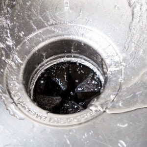water in a sink going down a garbage disposal