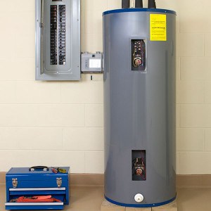 stock photo of a water heater next to open electrical panel and toolbox