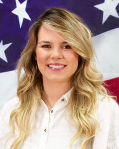 Madison wearing white shirt in front of flag background