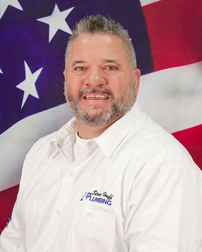 plumber named wade wearing white shirt sitting in front of American flag