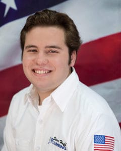 plumber in white shirt in front of American flag